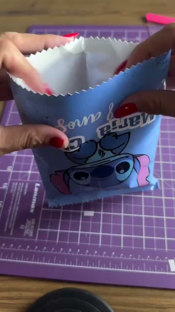 Hands assembling a printed Stitch treat bag