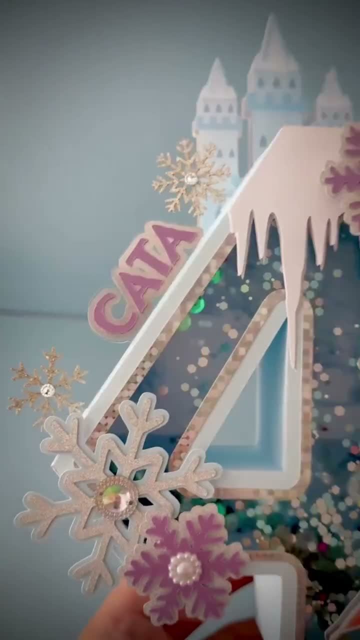 A handmade Frozen cake topper with a child's name